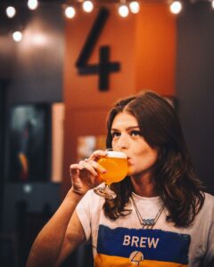 Woman drinking craft beer at Four City Brewing Company in Orange, NJ